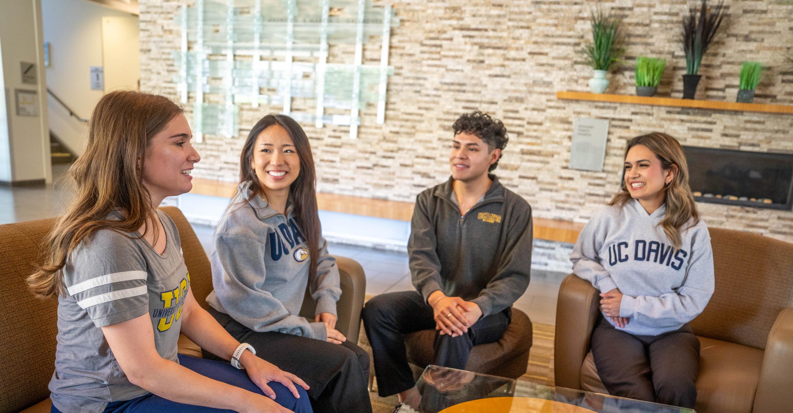 Four students sitting in the Gallagher Hall lobby