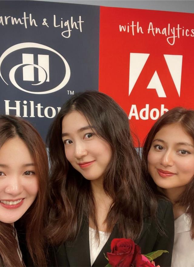 three women in front of adobe sign