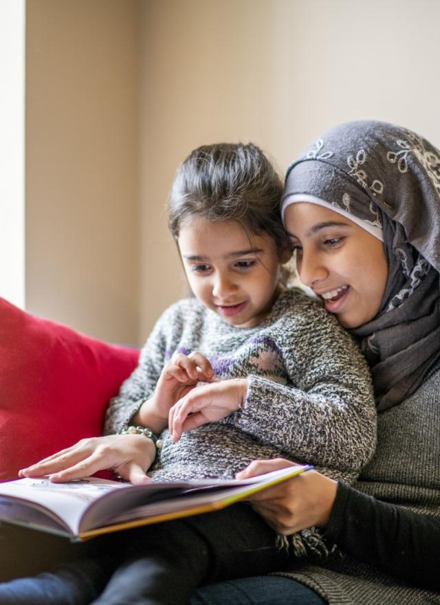 a woman holding a child and reading a book