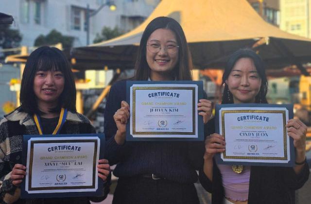 Mia Lai, Jihyun Kim and Cindy Jeon hold up their winning certificates of the Grand Champion Award 