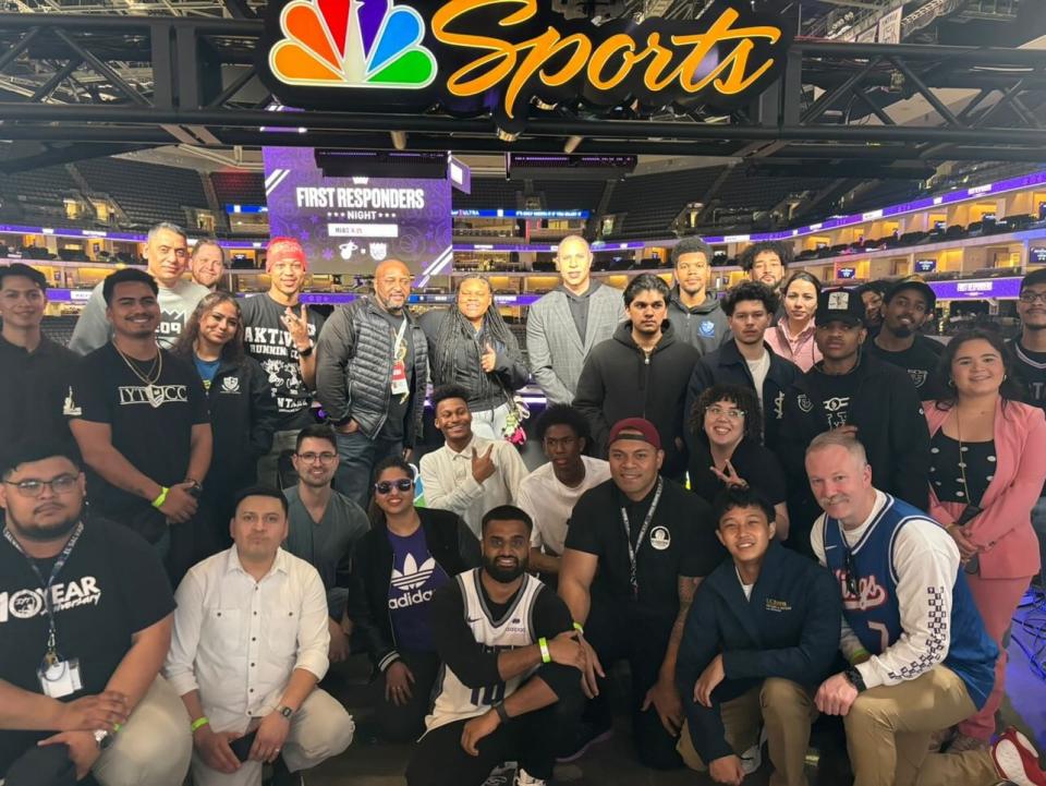 a group shot of mentees and MBA students at Golden 1 Center