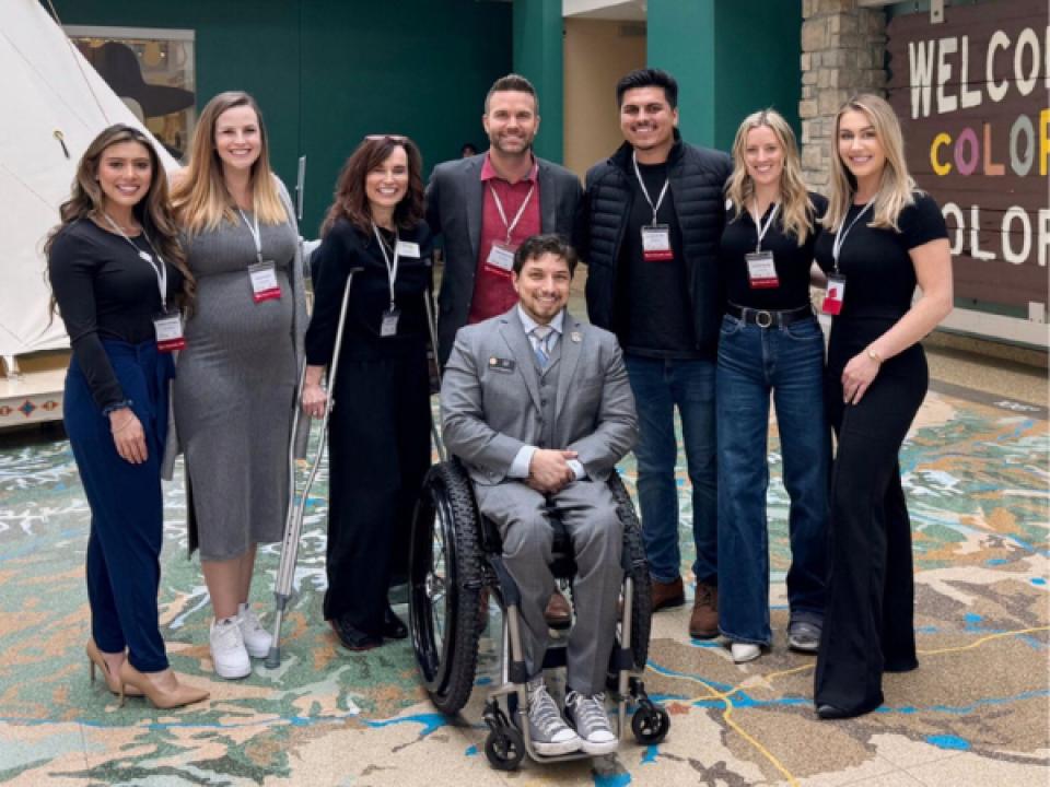 Mac Clemmens and staff wearing lanyards at conference