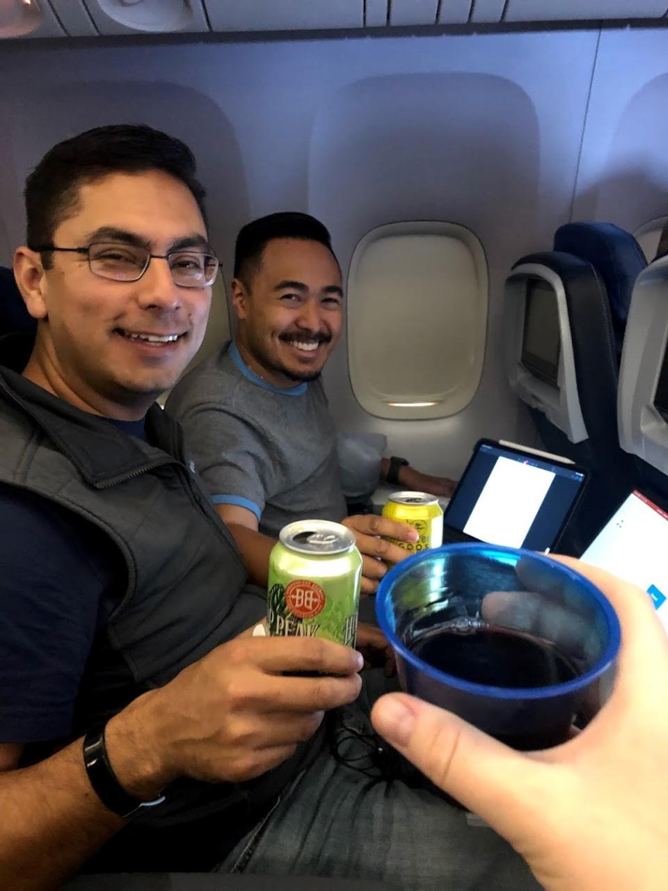 UC Davis MBA students Albert Contreras and Justin Virrey smiling for a photo on the plane