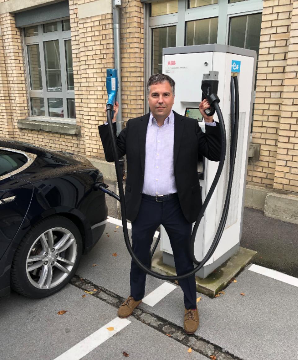 Daniel Student strikes a funny pose with the electric vehicle chargers at ABB, which was the focus of the team's research project