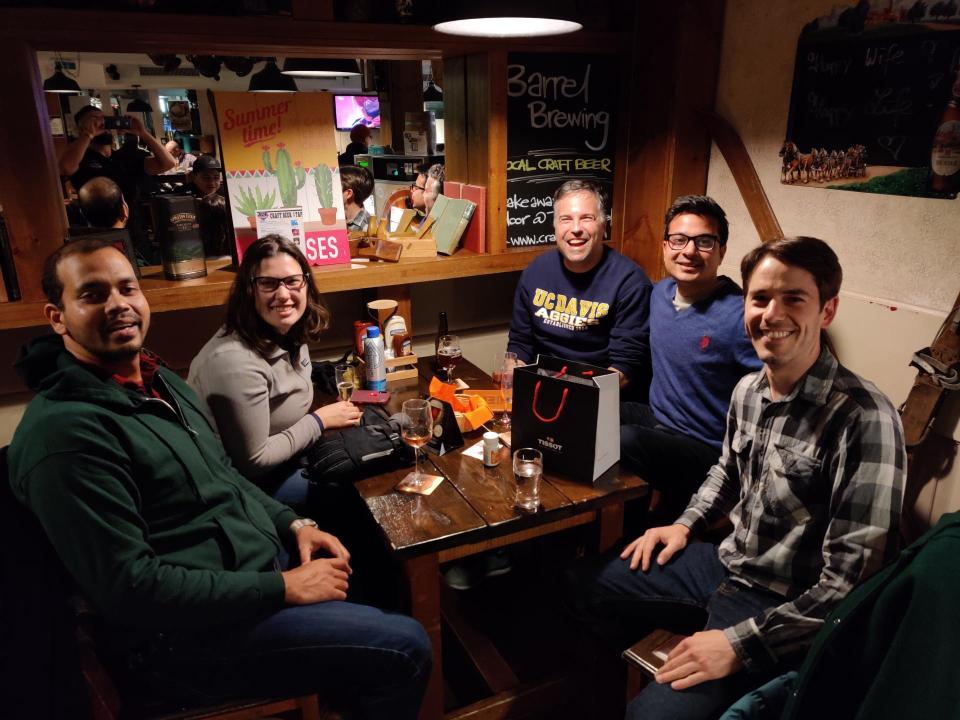 The UC Davis MBA team posing for a photo while eating a meal in a restaurant