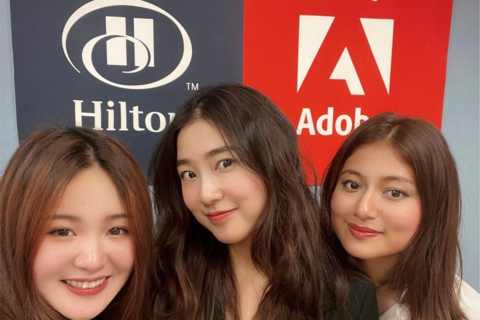three women in front of adobe sign