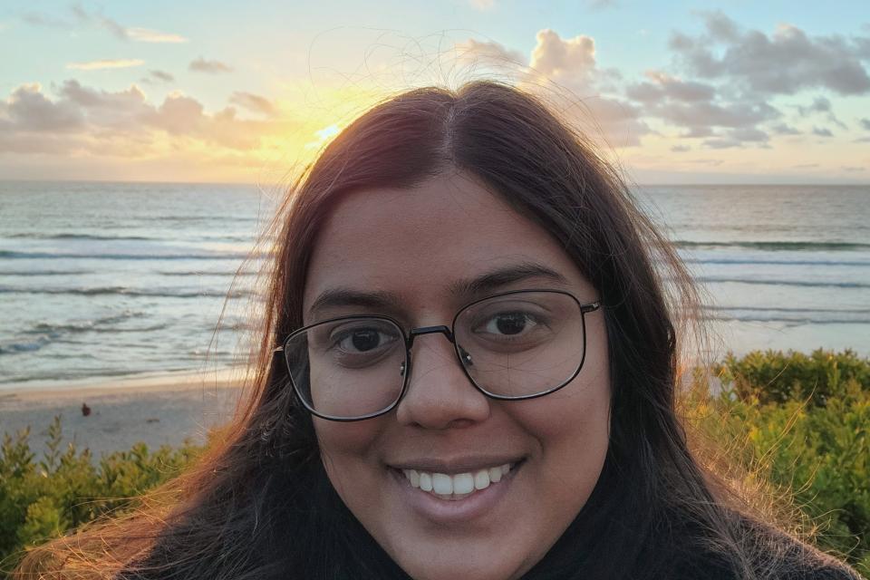 woman smiling in front of a sunset